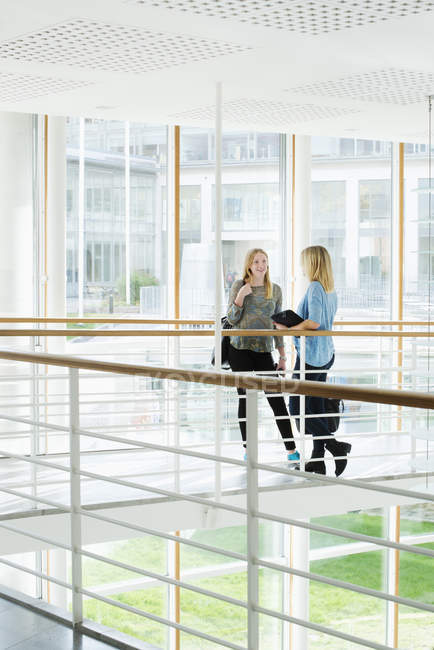 Jovens estudantes conversando no interior da universidade — Fotografia de Stock