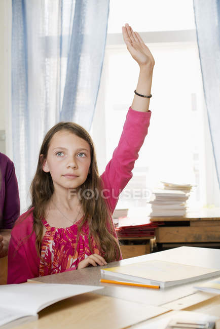 Studentin mit braunen Haaren hebt die Hand im Klassenzimmer — Stockfoto