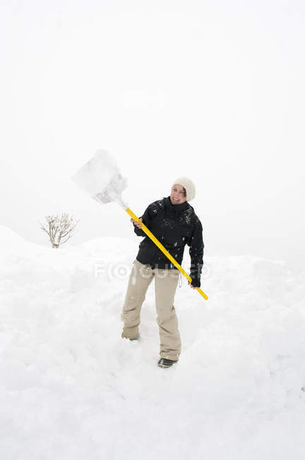 Frau mit Schneeschaufel in Vorarlberg, Österreich — Stockfoto