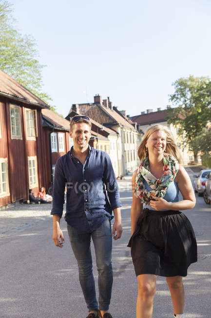 Fröhliches Paar, das die Straße entlanggeht, Fokus auf den Vordergrund — Stockfoto