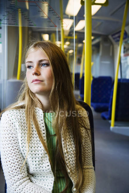 Adolescente chica en tren mirando hacia otro lado - foto de stock