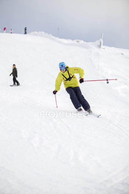 Mid adult man in warm clothing skiing — Stock Photo