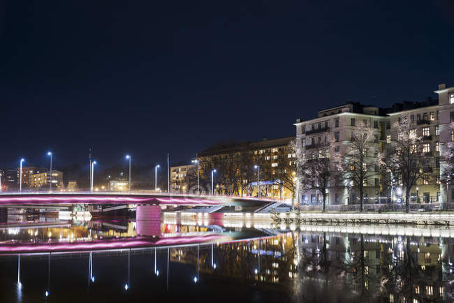 Vista panorámica de Turku con edificios iluminados exteriores y puente por la noche - foto de stock