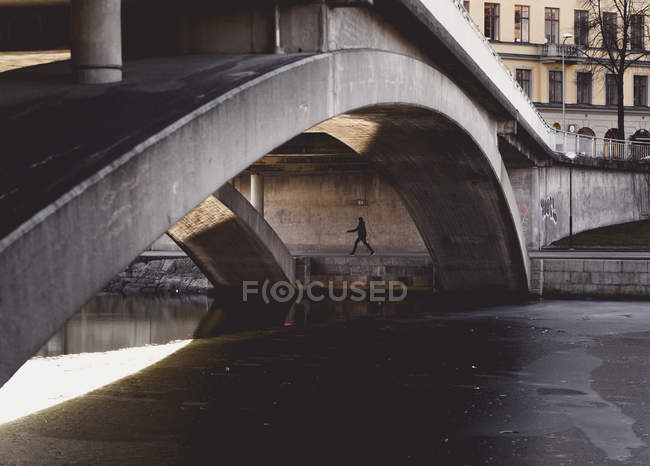 Person walking under bridge during winter in Stockholm, Sweden — Stock Photo