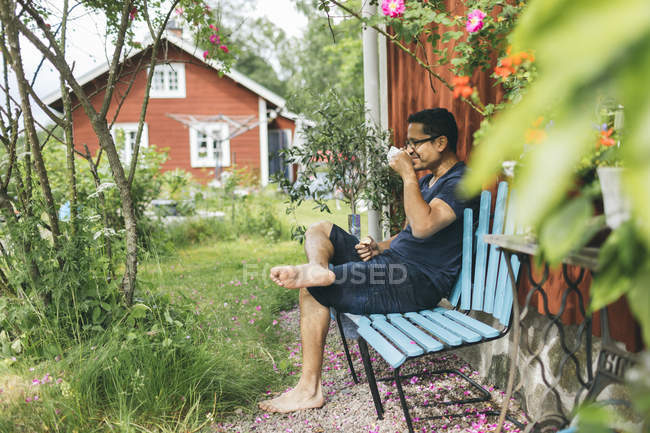 Mann trinkt Kaffee draußen in Mortfors, Schweden — Stockfoto