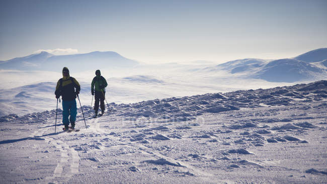 Задний вид двух туристов на снегу в Йенланде, Швеция — стоковое фото