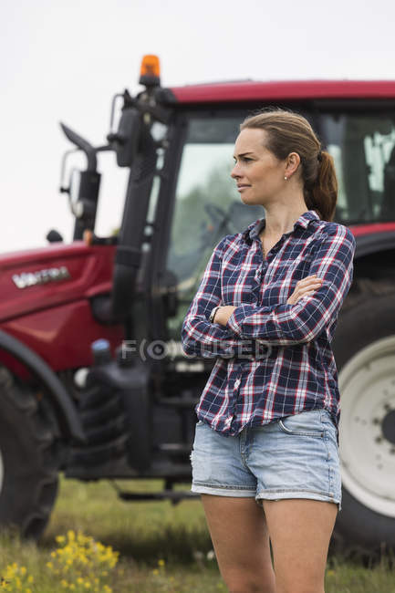 Trabalhador agrícola em pé na frente do trator, foco em primeiro plano — Fotografia de Stock