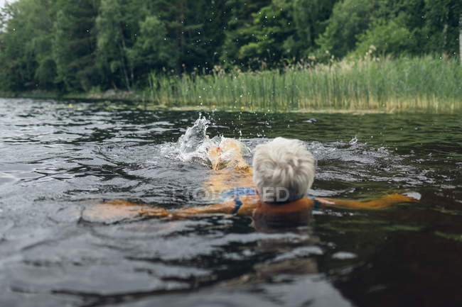 Seniorin schwimmt im See Kappemalgol, Schweden — Stockfoto