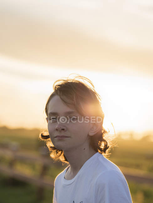 Хлопчик-підліток на свіжому повітрі під час заходу сонця, зосередитися на передньому плані — стокове фото