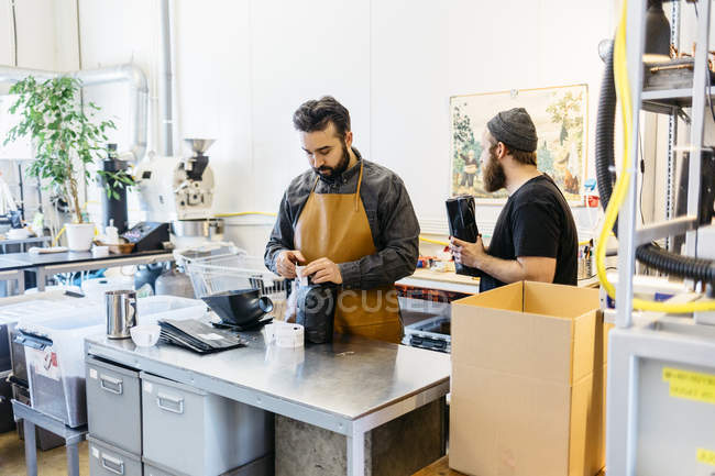 Dois homens fazendo café na cozinha comercial, foco seletivo — Fotografia de Stock
