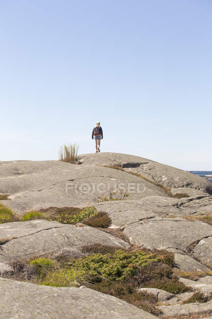 Menina caminhando sobre a formação de rocha em Bohuslan, Suécia — Fotografia de Stock