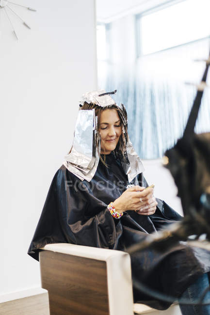Cliente di parrucchiere con lamina di metallo nei capelli, concentrarsi sul primo piano — Foto stock