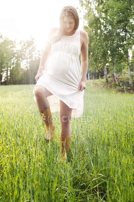 Pregnant woman standing at field, selective focus — Stock Photo
