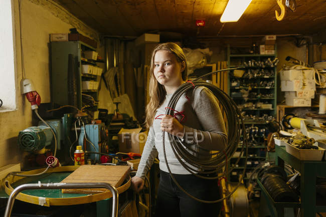 Adolescente menina segurando bobina de corda na loja fabricante de corda — Fotografia de Stock