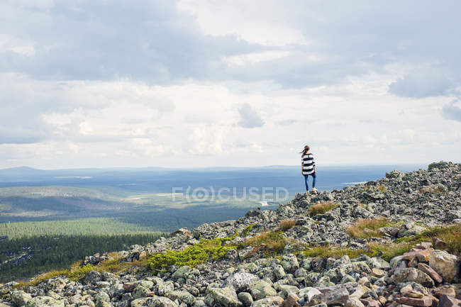 Mulher de pé sobre rochas em Kittila, Finlândia — Fotografia de Stock