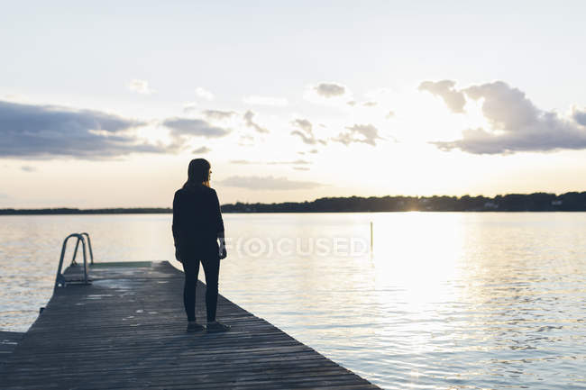 Mid adult woman standing on pier, focus on foreground — Stock Photo