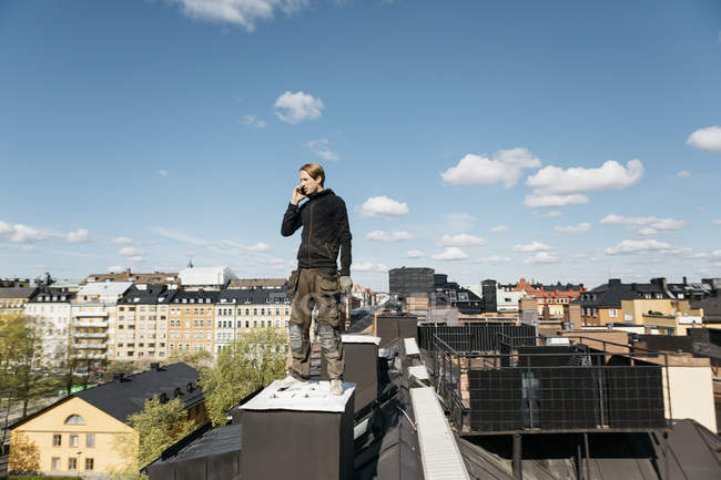 Dachdecker unterhält sich während der Arbeitspause auf dem Smartphone in Stockholm, Schweden — Stockfoto