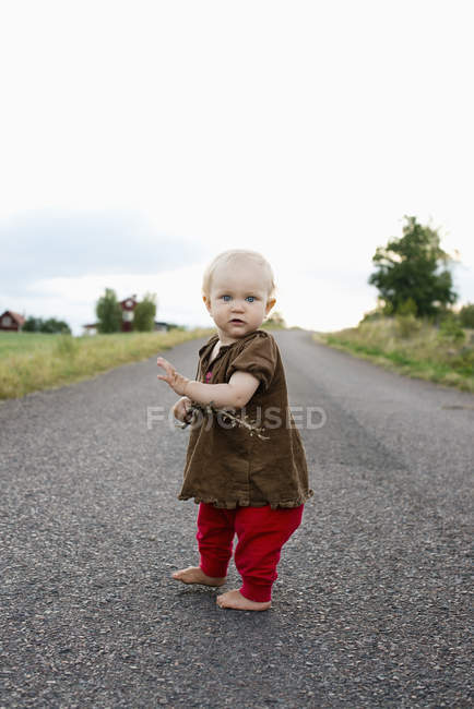 Bébé fille debout sur la route rurale à Smaland, Suède — Photo de stock