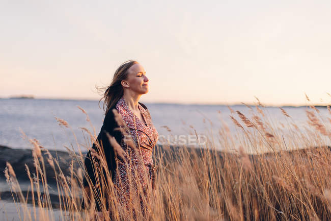 Glückliche frau entspannt sich am strand in blekinge, schweden — Stockfoto