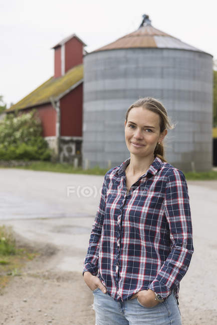 Trabalhador agrícola em pé contra silo, foco em primeiro plano — Fotografia de Stock