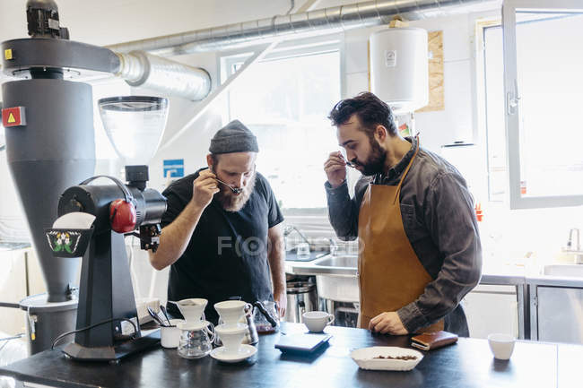 Two men testing coffee at commercial kitchen, selective focus — Stock Photo