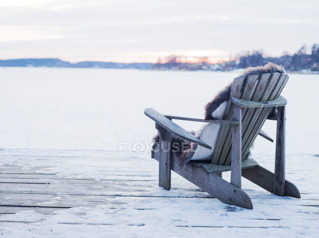 Sedia in legno sul ponte nella neve a Sigtuna, Svezia — Foto stock