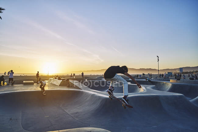 Side view of teenage boy skateboarding at Venice Beach, USA — Stock Photo