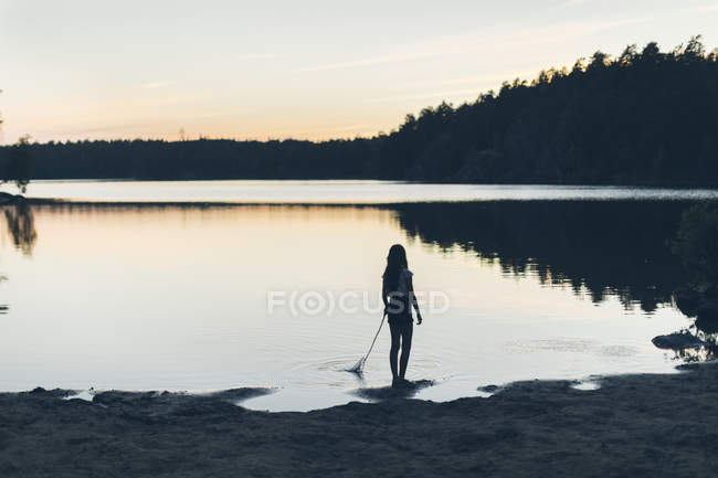 Дівчина на озері під час заходу сонця в Швеції — стокове фото