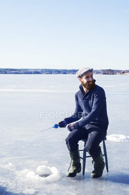 Man fishing on frozen lake in Dalarna, Sweden — Stock Photo