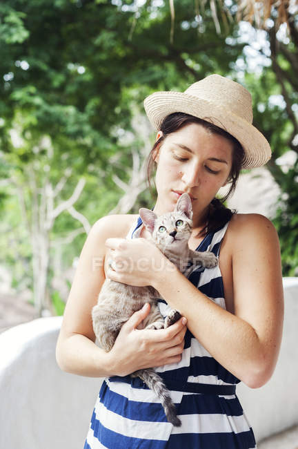 Young woman holding kitten, focus on foreground — Stock Photo