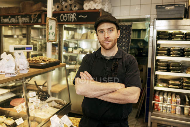 Portrait of fishmonger with arms crossed in store, selective focus — Stock Photo