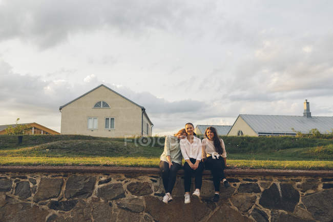Tre giovani donne sedute sul muro a Karlskrona, Svezia — Foto stock