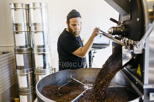 Человек с помощью кофе обжига машина, избирательный фокус — стоковое фото
