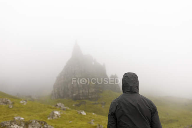 Woman wearing hood by Old Man of Storr on Isle of Skye, Scotland — Stock Photo