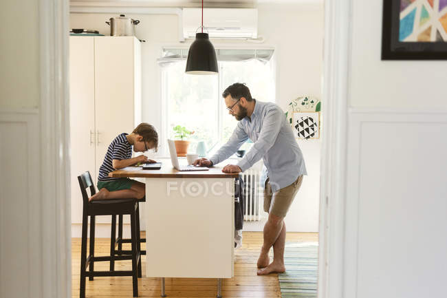 Seitenansicht von Vater und Junge mit Geräten in der häuslichen Küche — Stockfoto