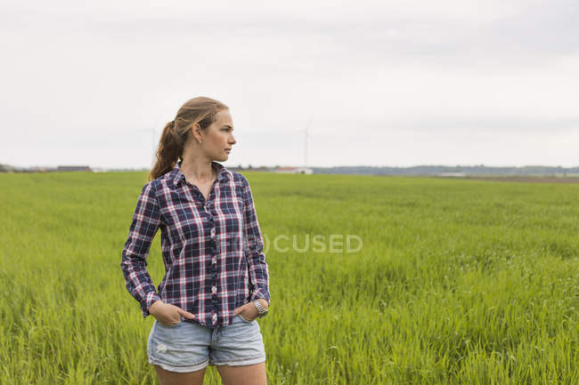 Сільськогосподарський працівник, що стоїть на полі, зосередитися на передньому плані — стокове фото
