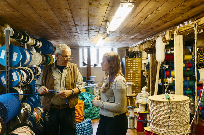 Produttore di corde che parla con l'apprendista in negozio, attenzione selettiva — Foto stock