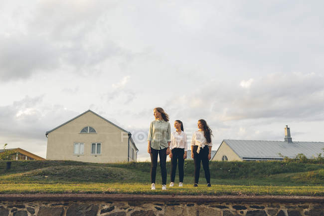 Three young women standing on wall in Karlskrona, Sweden — Stock Photo