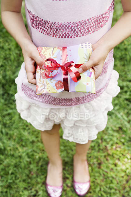 Vista cortada de menina segurando presente na festa de aniversário — Fotografia de Stock