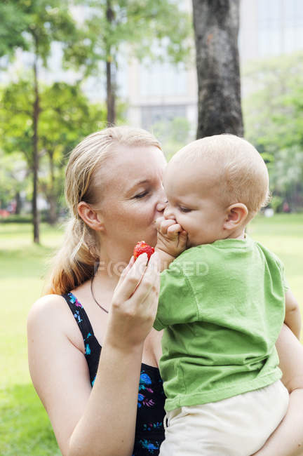 Madre besando hijo, concéntrate en el primer plano - foto de stock