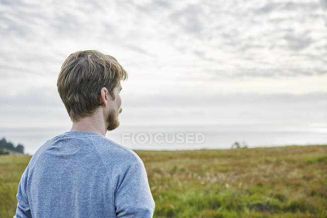 Mitte erwachsener Mann auf Feld in Kalifornien, USA, Fokus auf den Vordergrund — Stockfoto