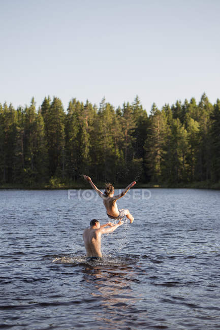 Uomo gettando ragazzo adolescente nel lago a Kilsbergen, Svezia — Foto stock