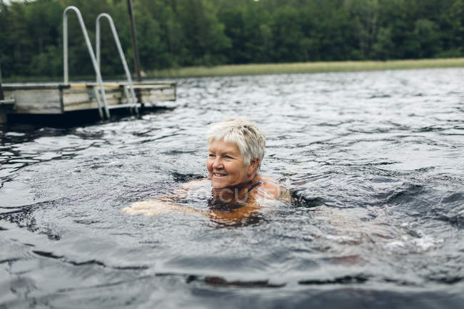 Femme âgée nageant dans le lac Kappemalgol, Suède — Photo de stock
