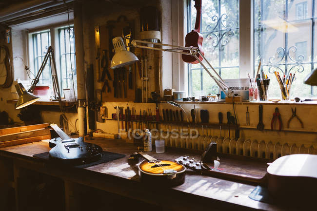 Guitarras no banco na oficina de fabricação de guitarras, foco seletivo — Fotografia de Stock