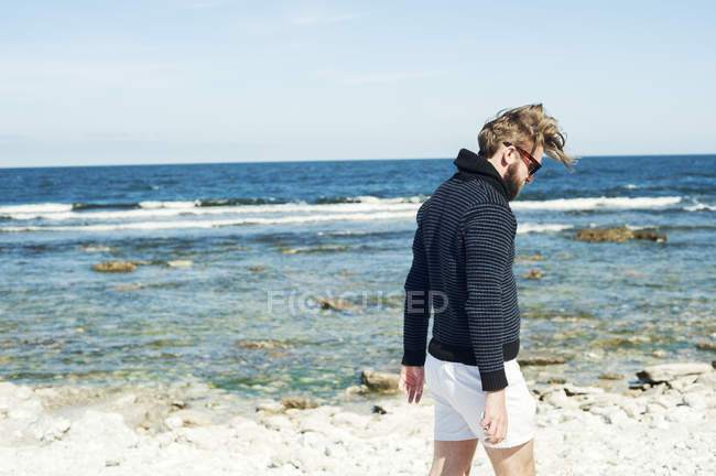Junger mann spaziert am strand in gotland, schweden — Stockfoto