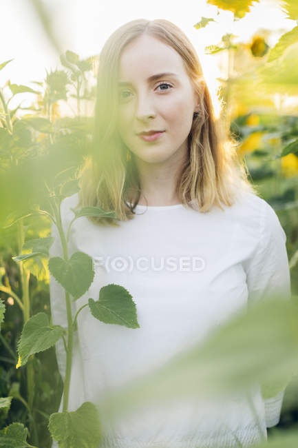 Молода жінка стояла в полі на Соняшники в Karlskrona, Швеція — стокове фото