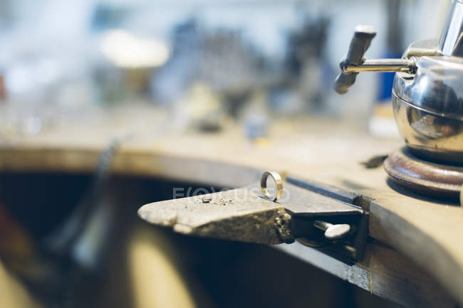 Goldring in Schraubstock in der Werkstatt, Hintergrund mit weichem Fokus — Stockfoto