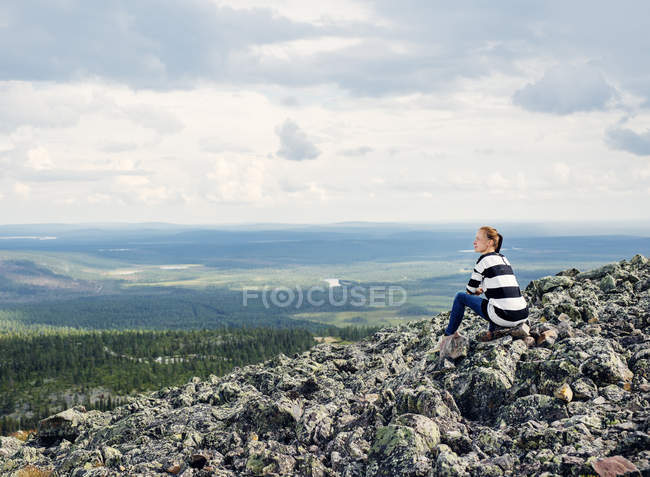 Donna seduta sulle rocce a Kittila, Finlandia — Foto stock