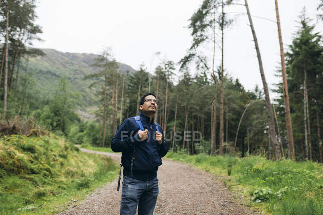 Homem de pé na estrada rural em Glen Coe, Escócia — Fotografia de Stock