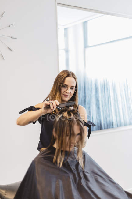 Hairdresser cutting clients hair in salon, selective focus — Stock Photo